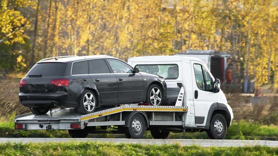 Ein Auto wird auf einem Abschleppwagen verladen und kostenlos bei Autoankauf Passau abgeholt 